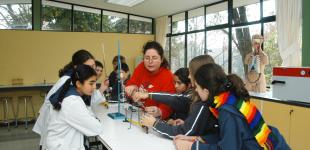 Estudiantes con docentes realizando experimento en laboratorio de ciencias