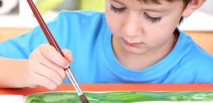 Se obaserva a un niño pintando con distintos colores