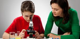 Adolescente observando muestras con un miscroscopio