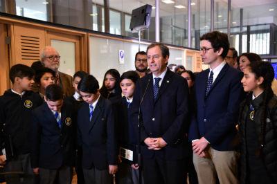 Fotografía del ministro de Educación Gerardo Varela y estudiantes chilenos.
