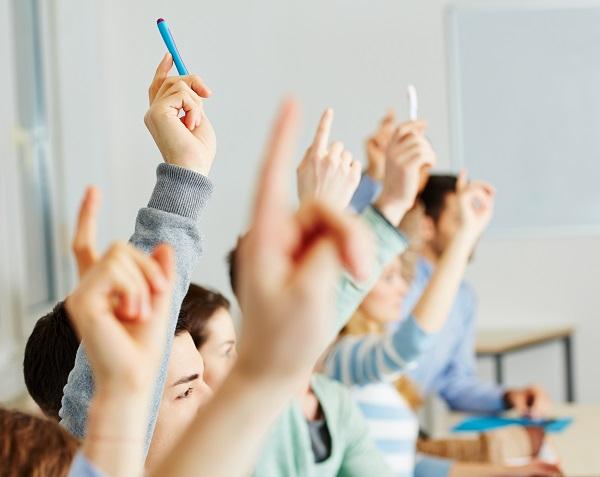 Estudiantes levantando la mano para participar en clases